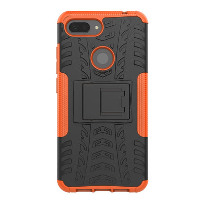 Rugged orange phone case back with tire tread pattern, ring stand, and camera cutout