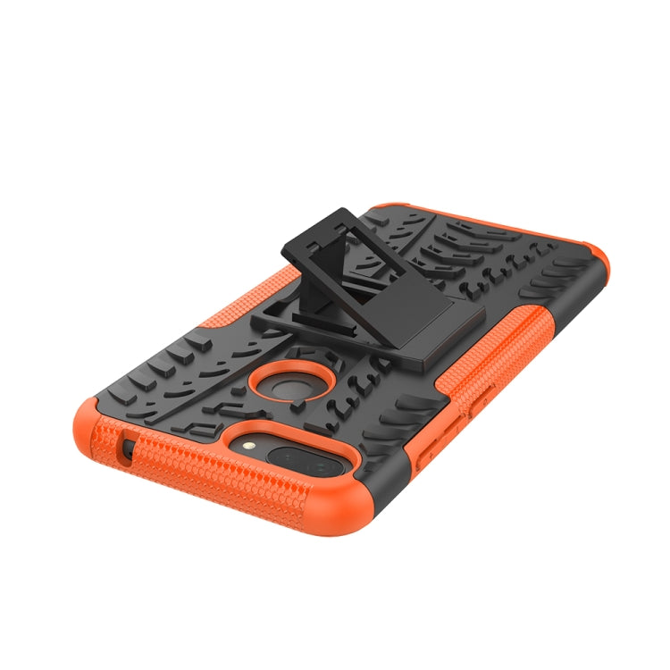 Rugged orange-and-black phone case with raised holder, tire tread grip, and camera cutout